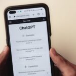 Webpage of ChatGPT, a prototype AI chatbot, is seen on the website of OpenAI, on a smartphone. Examples, capabilities, and limitations are shown.